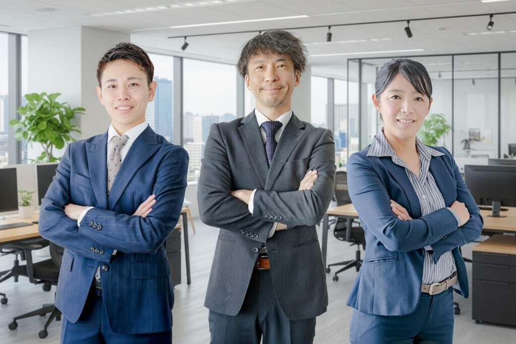 腕を組んで笑顔で並ぶスーツ姿の男女